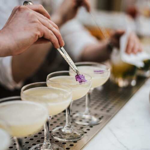 Closeup shot of a barman making margaritas with five glasses set in line A closeup shot of a barman making margaritas with five glasses set in line
