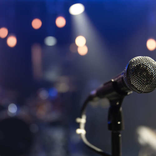 Close up microphone on blurred background with bokeh. Close up of a microphone on a concert stage with beautiful lighting.